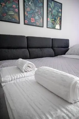 a bed with two white towels on top of it at AthensAPTS in Athens
