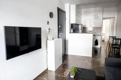 a living room with a large flat screen tv on a wall at AthensAPTS in Athens