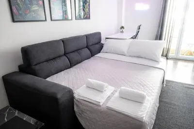 a bed with two white towels on top of it at AthensAPTS in Athens