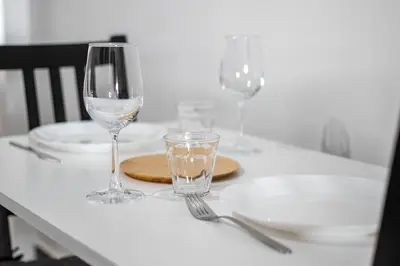 a table with three wine glasses and plates on it at AthensAPTS in Athens