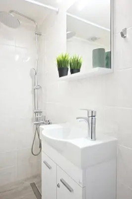 a white bathroom with a sink and a mirror at AthensAPTS in Athens