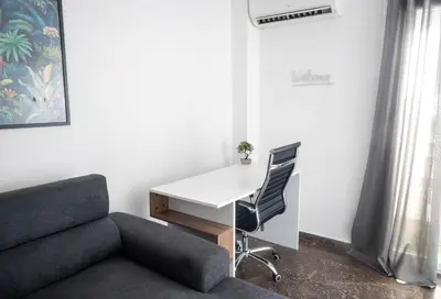 a office with a couch and a desk and a desk and a chair at AthensAPTS in Athens