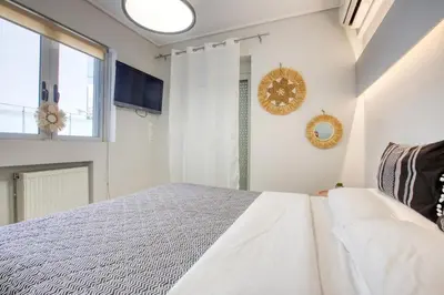 a white bedroom with a bed and a window at Saronida Hills private Pool in Saronida