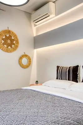 a white bedroom with a bed and a mirror at Saronida Hills private Pool in Saronida