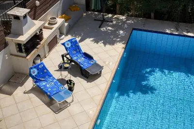 an overhead view of a swimming pool with two blue chairs at Saronida Hills private Pool in Saronida