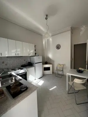 a kitchen with white cabinets and a table in it at Sirius Escape in Spáta