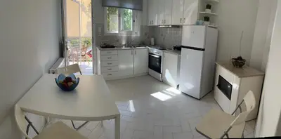 a kitchen with white appliances and a table and chairs at Sirius Escape in Spáta