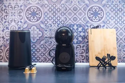 a black blender sitting on top of a table with knives at Athens Seaside Retreat Floisvos in Athens