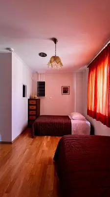 a hotel room with two beds and a chandelier at Alexandros suite in Athens
