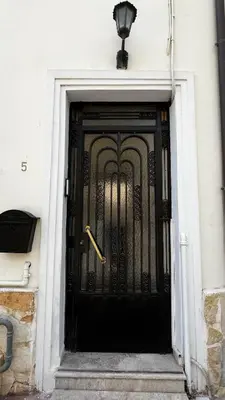 a black door with a gold handle on a building at Alexandros suite in Athens