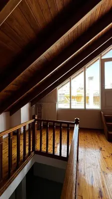 an empty room with a wooden floor and windows at Alexandros suite in Athens