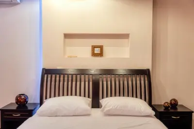 a bed with two pillows on top of it at Alexandros suite in Athens