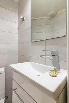 a bathroom with a white sink and a mirror at Spacious Apt Next to Marina Flisvo in Athens
