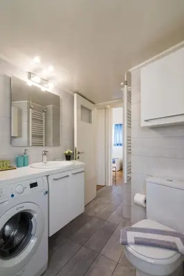 a bathroom with a washing machine and a sink at Spacious Apt Next to Marina Flisvo in Athens
