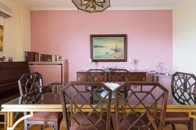 a dining room with pink walls and a table and chairs at Spacious Apt Next to Marina Flisvo in Athens