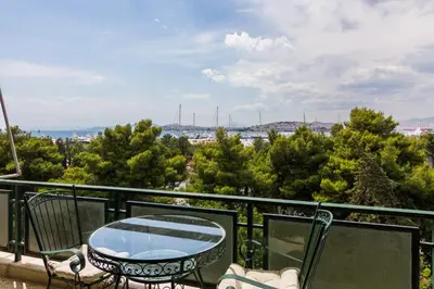 a patio with a table and chairs on a balcony at Spacious Apt Next to Marina Flisvo in Athens