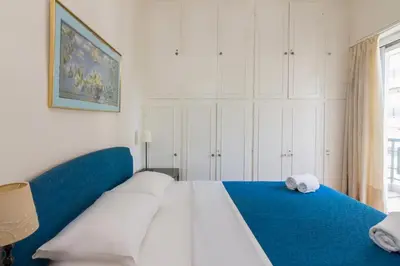 a bedroom with a large white bed with a blue blanket at Spacious Apt Next to Marina Flisvo in Athens