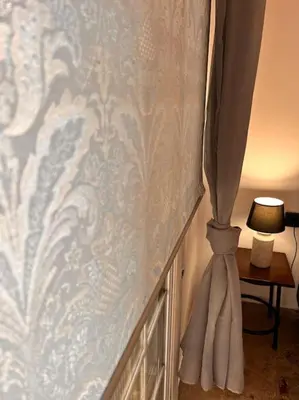 a bedroom with a curtain and a table with a lamp at Athena3 in Athens