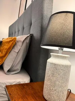 a lamp sitting on a table next to a bed at Athena3 in Athens