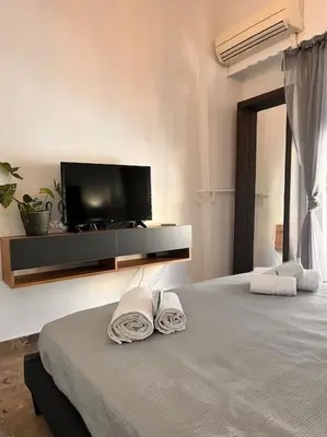 a bedroom with a tv and a bed with towels at Athena3 in Athens