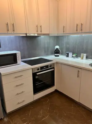 a kitchen with white cabinets and a stove top oven at Athena3 in Athens