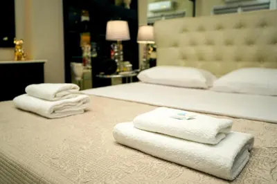 two beds with towels on the floor in a bedroom at Sea Breeze Beachfront Apartment VIPGreece in Athens