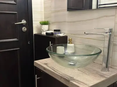 a bathroom with a glass bowl sink on a counter at Sea Breeze Beachfront Apartment VIPGreece in Athens