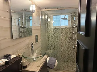a bathroom with a glass sink and a shower at Sea Breeze Beachfront Apartment VIPGreece in Athens