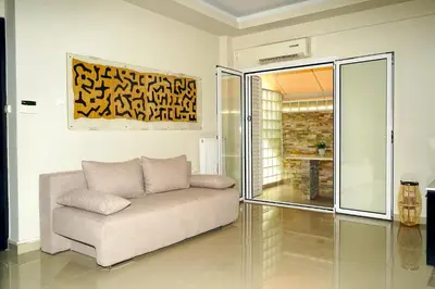 a living room with a couch and a painting at Sea Breeze Beachfront Apartment VIPGreece in Athens