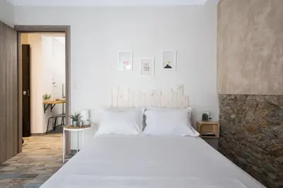 a bedroom with a large bed with white sheets at Special studio in the heart of Athens! in Athens