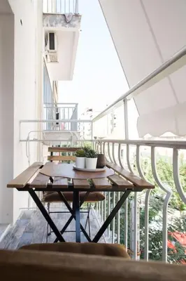 a table on a balcony with a plant on it at Special studio in the heart of Athens! in Athens