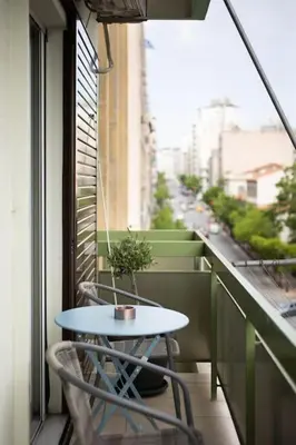a table and chairs on a balcony with a window at Majestic and spacious apartment near Acropolis in Athens