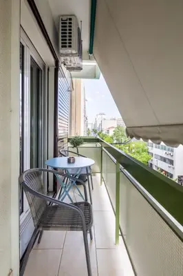 a balcony with a table and chairs on a building at Majestic and spacious apartment near Acropolis in Athens