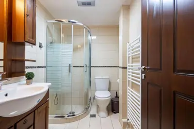 a bathroom with a toilet and a glass shower at Majestic and spacious apartment near Acropolis in Athens