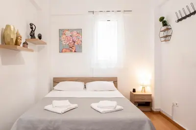 a bedroom with a bed with white sheets and towels at Athinais in Athens