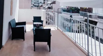 a balcony with two chairs and a table on a building at Athinais in Athens