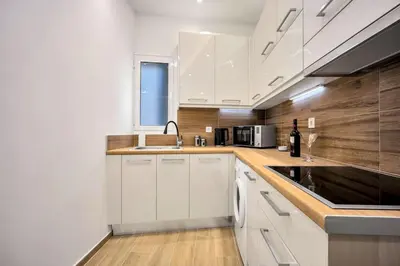 a kitchen with white cabinets and a sink at Artemis Modern Apartment in Athens