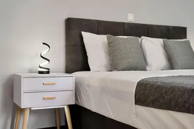 a bedroom with a bed with a nightstand and a bed sidx sidx at Artemis Modern Apartment in Athens