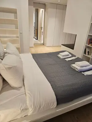 a large bed with white sheets and pillows on it at Athenian Spirit by Acropolis in Athens
