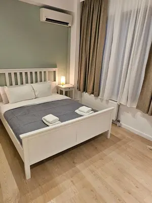 a bedroom with a large white bed in front of a window at Athenian Spirit by Acropolis in Athens