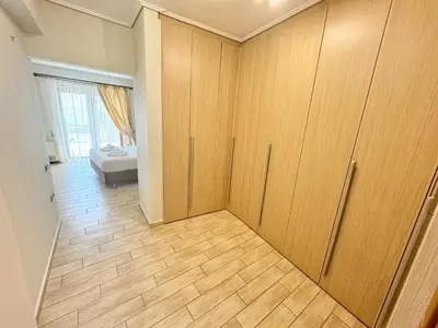 a room with wooden cabinets and a room with a bed at Stone Villa Saronida in Saronida