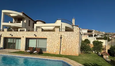 a villa with a swimming pool next to a house at Stone Villa Saronida in Saronida
