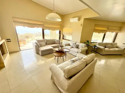 a large living room with couches and a table at Stone Villa Saronida in Saronida