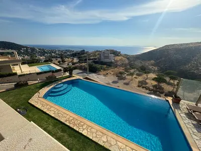 a swimming pool with a view of the ocean at Stone Villa Saronida in Saronida