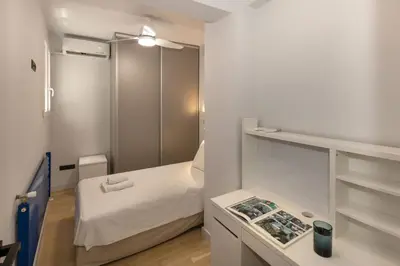 a small white room with a bed and a table at Well-designed apartment by the Acropolis GHH in Athens