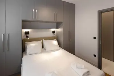 a bedroom with a bed with white sheets and white pillows at Well-designed apartment by the Acropolis GHH in Athens