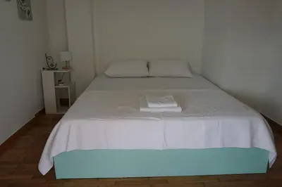a white bed with a white blanket on it at Urban Apartment Psiri in Athens