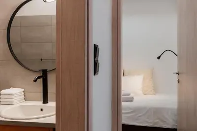 a bathroom with a mirror and a sink and a bed at Dylan in Athens