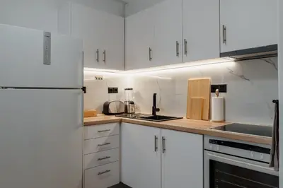 a kitchen with white cabinets and a white refrigerator at Dylan in Athens