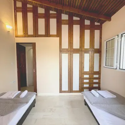 two beds sitting in a room with windows at Sounio Poseidon Villa in Sounio